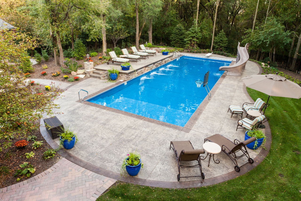 Lush backyard with a finished swimming pool showcasing automatic swimming pool cover parts SE WI